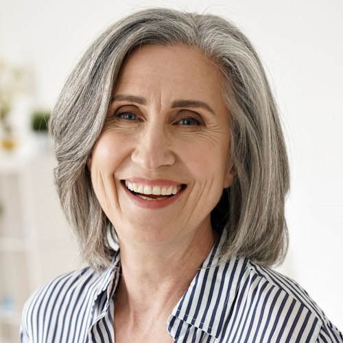 A woman of middle age is smiling, revealing dentures in Marietta.